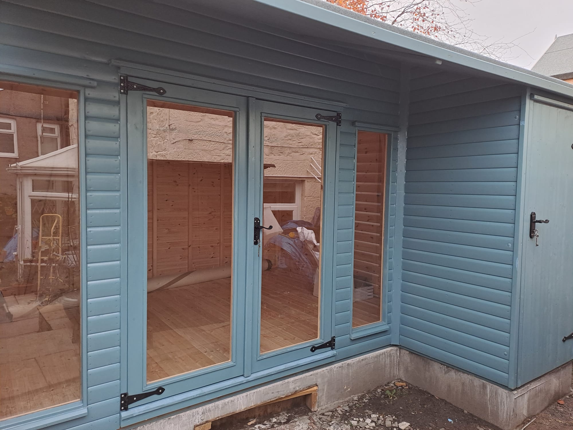 Close view of the glazed doors on a blue grey summer house
