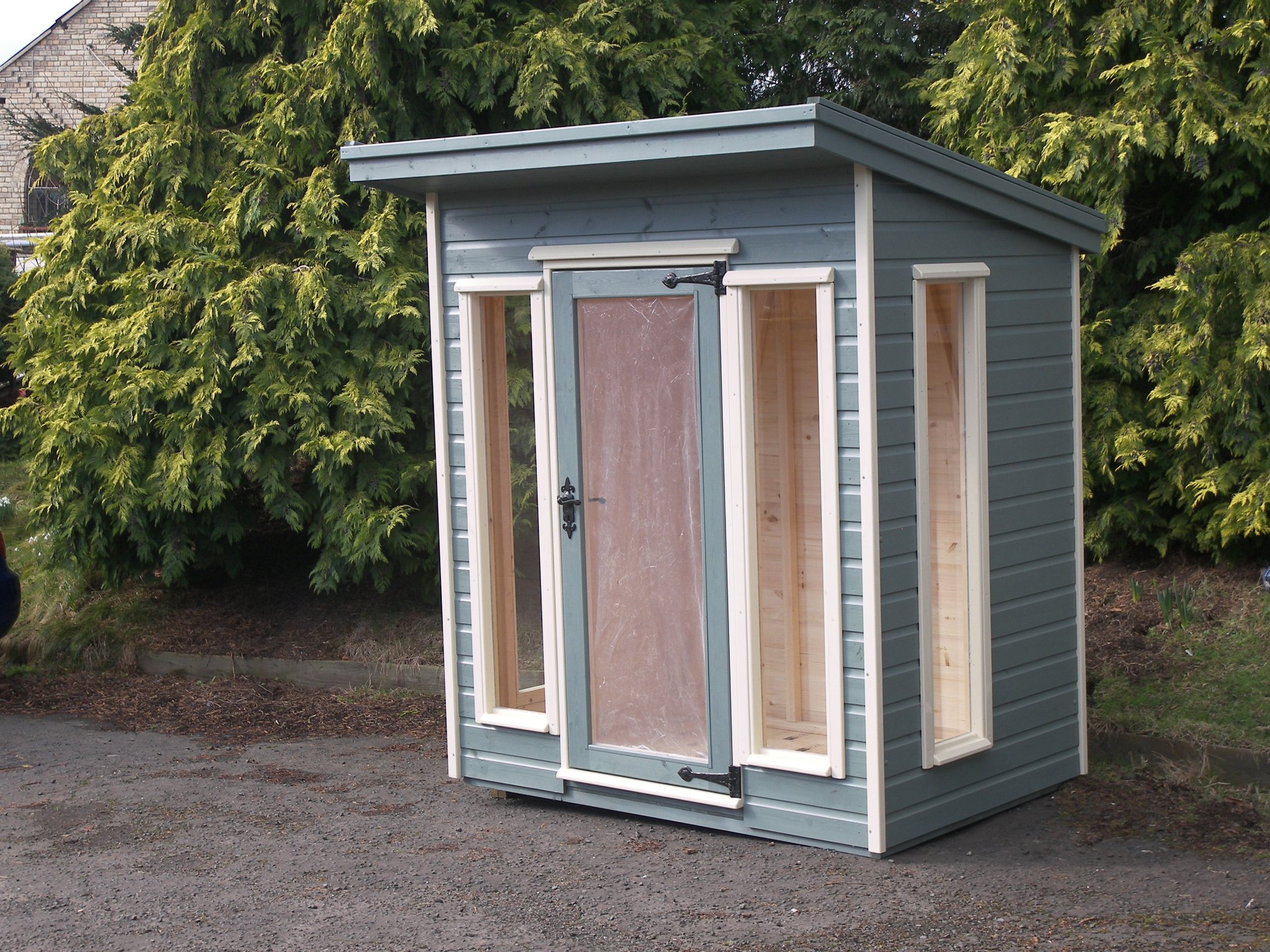 Sage pent roof summer house with cream window frames