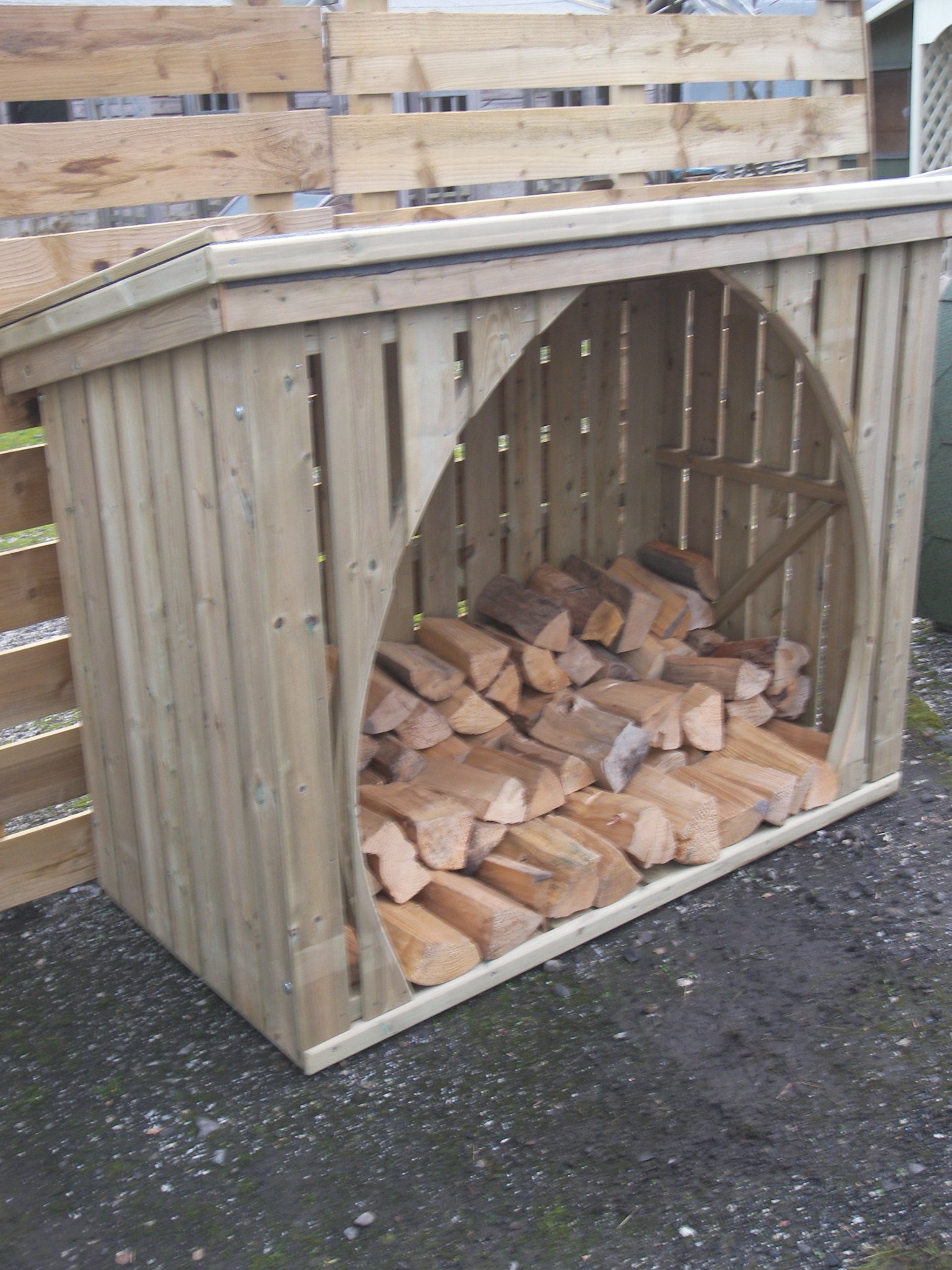Radial log store with a curved opening filled with split logs