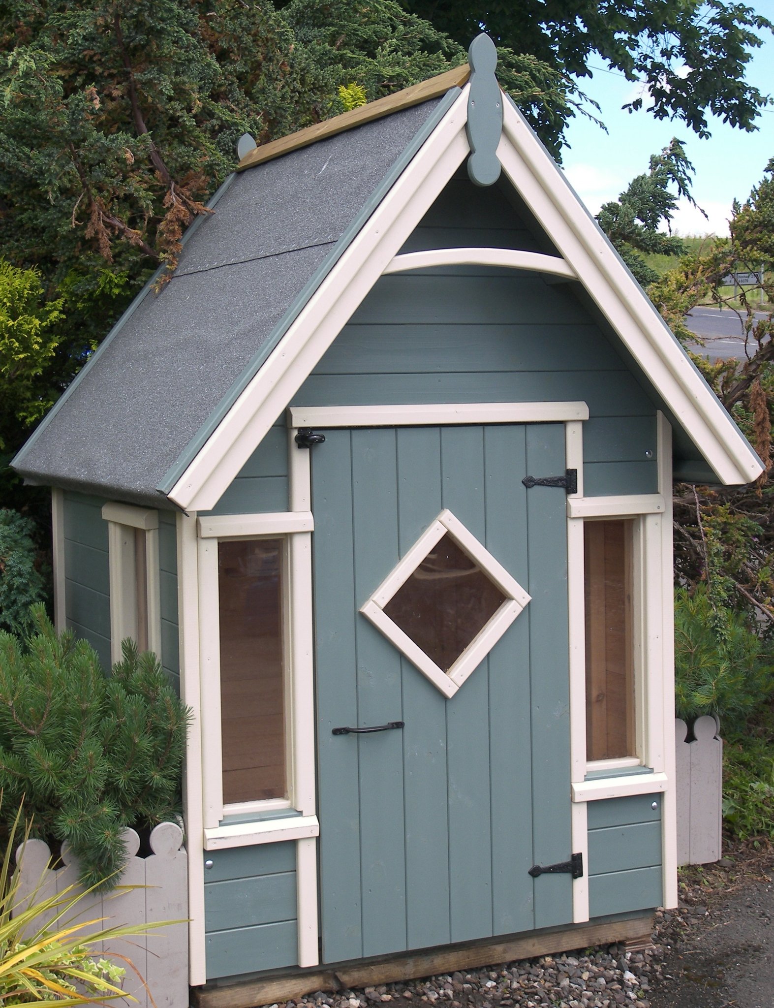 Sage play house with a diamond window and arched bargeboard