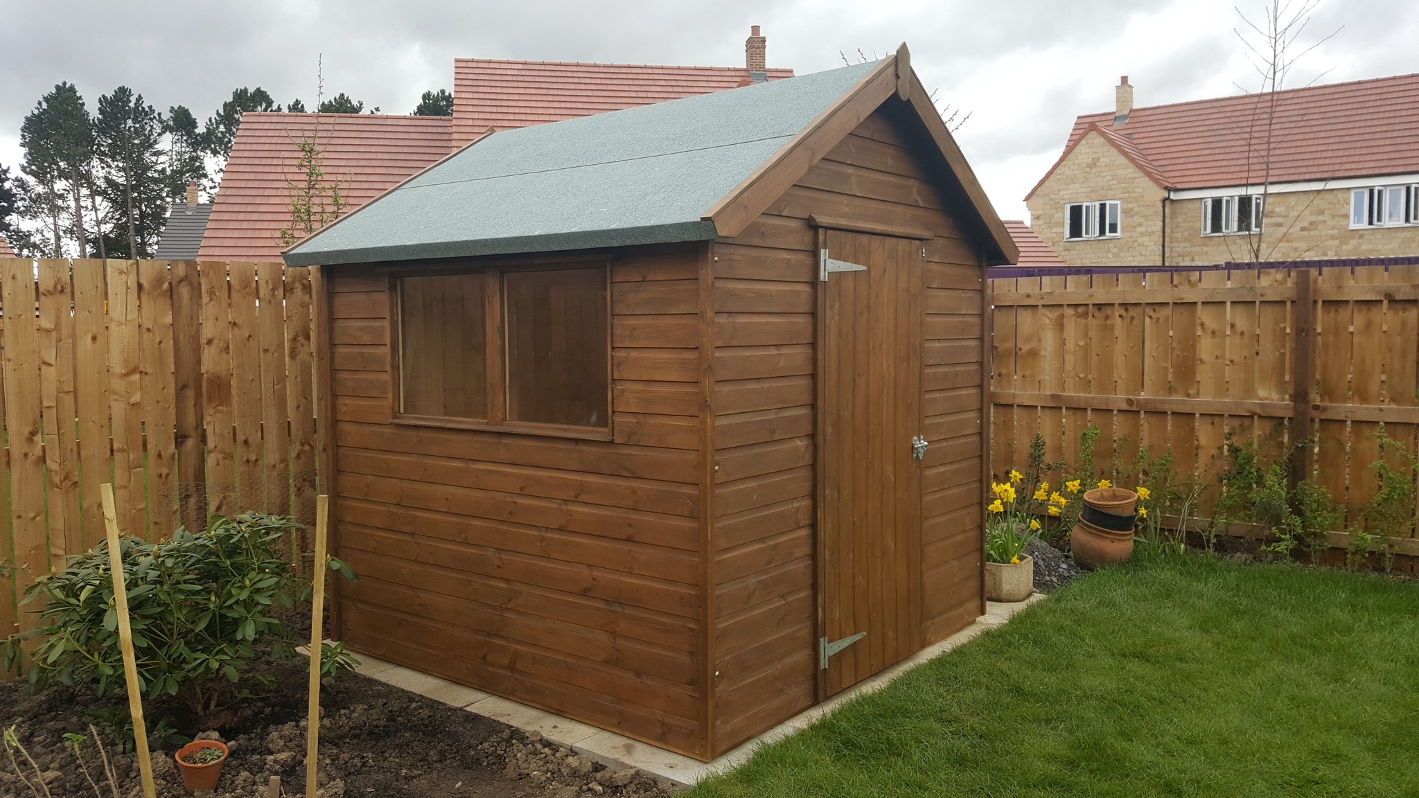 Stained apex shed in a newly fenced garden