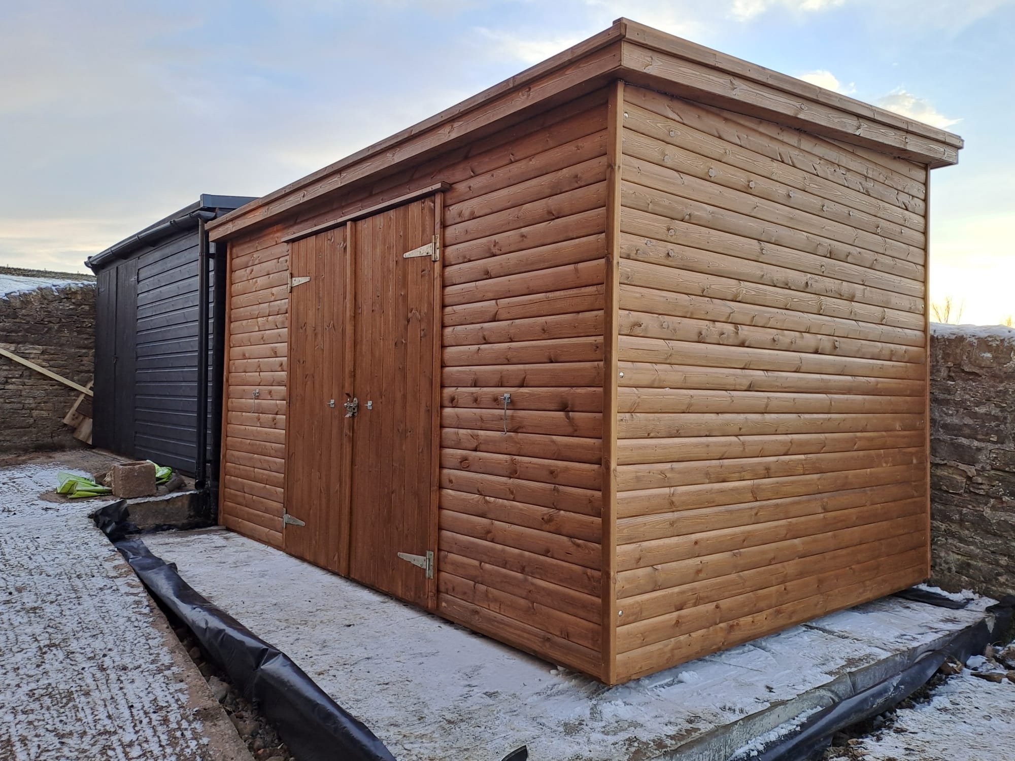 Stained pent shed with double doors on a new base