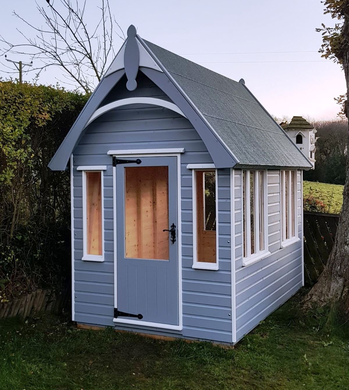 Blue summer house with an arched bargeboard and finial