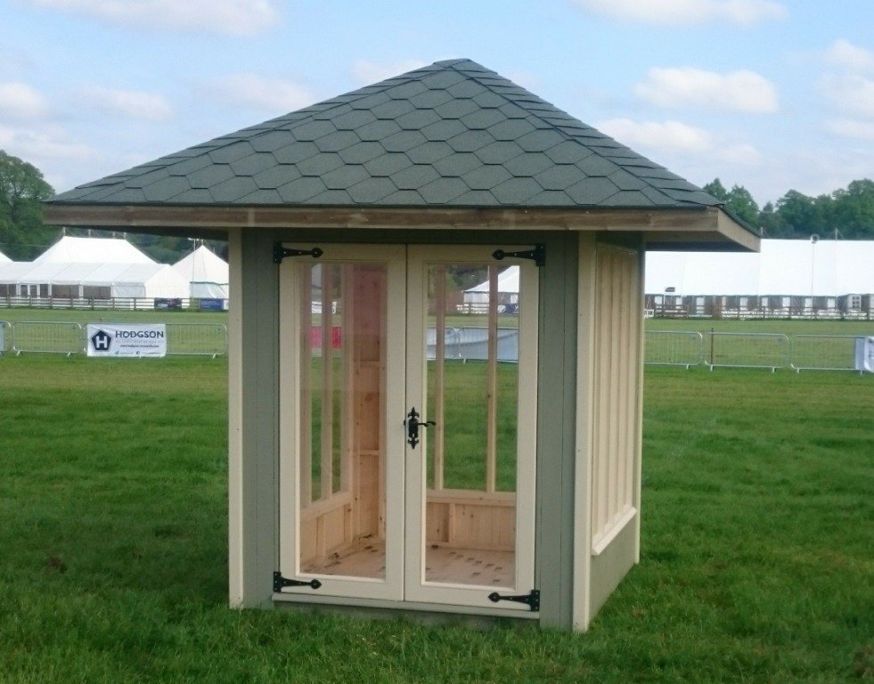 Painted summer house with a tiled pyramid roof on a showground