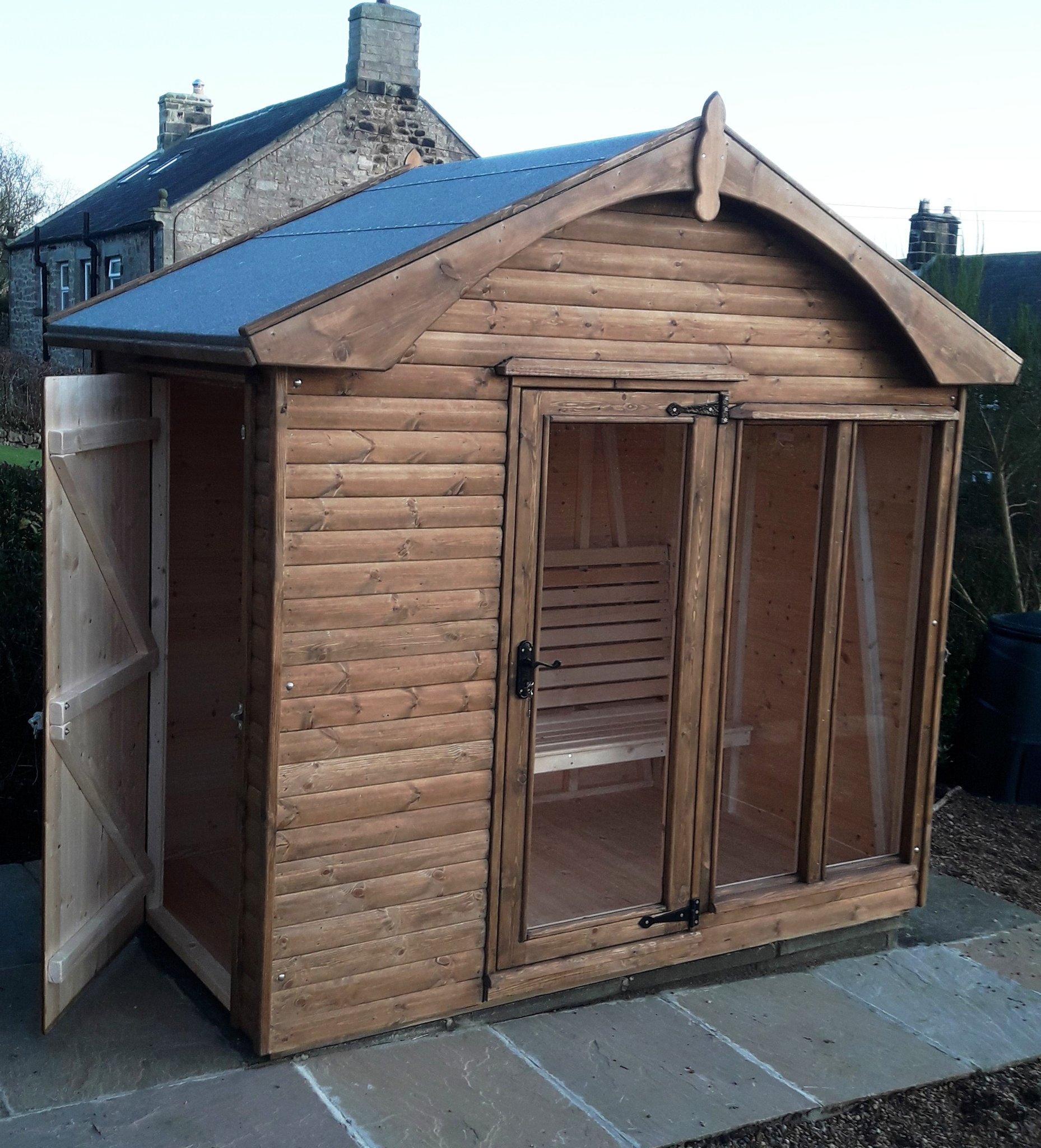 Stained summer house with an arched roof and open door